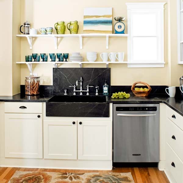 Modern kitchen is white with a black marble countertop. Stove, oven,  cabinets and sink with tap Stock Photo - Alamy