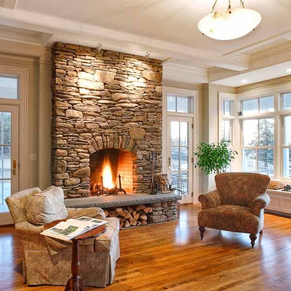 Burning fireplace with a stone veneer front in a living room.