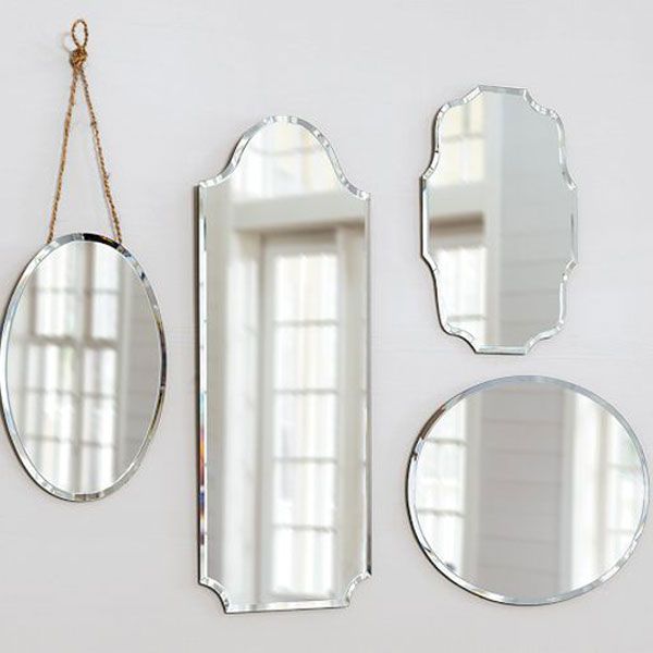 Four different styles of mirror hanging together on a wall.