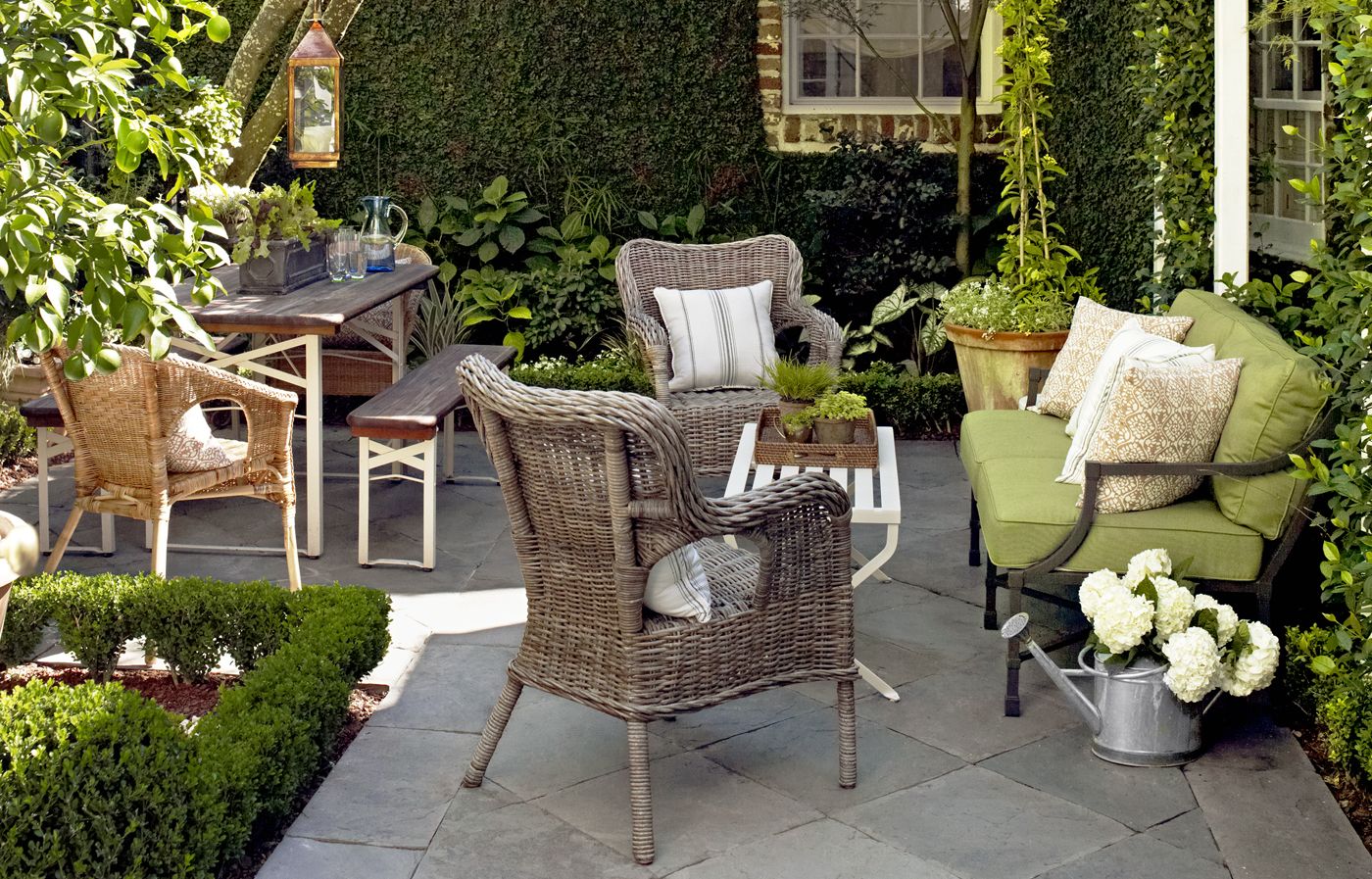 A home patio, filled with a couch and a few wicker chairs.