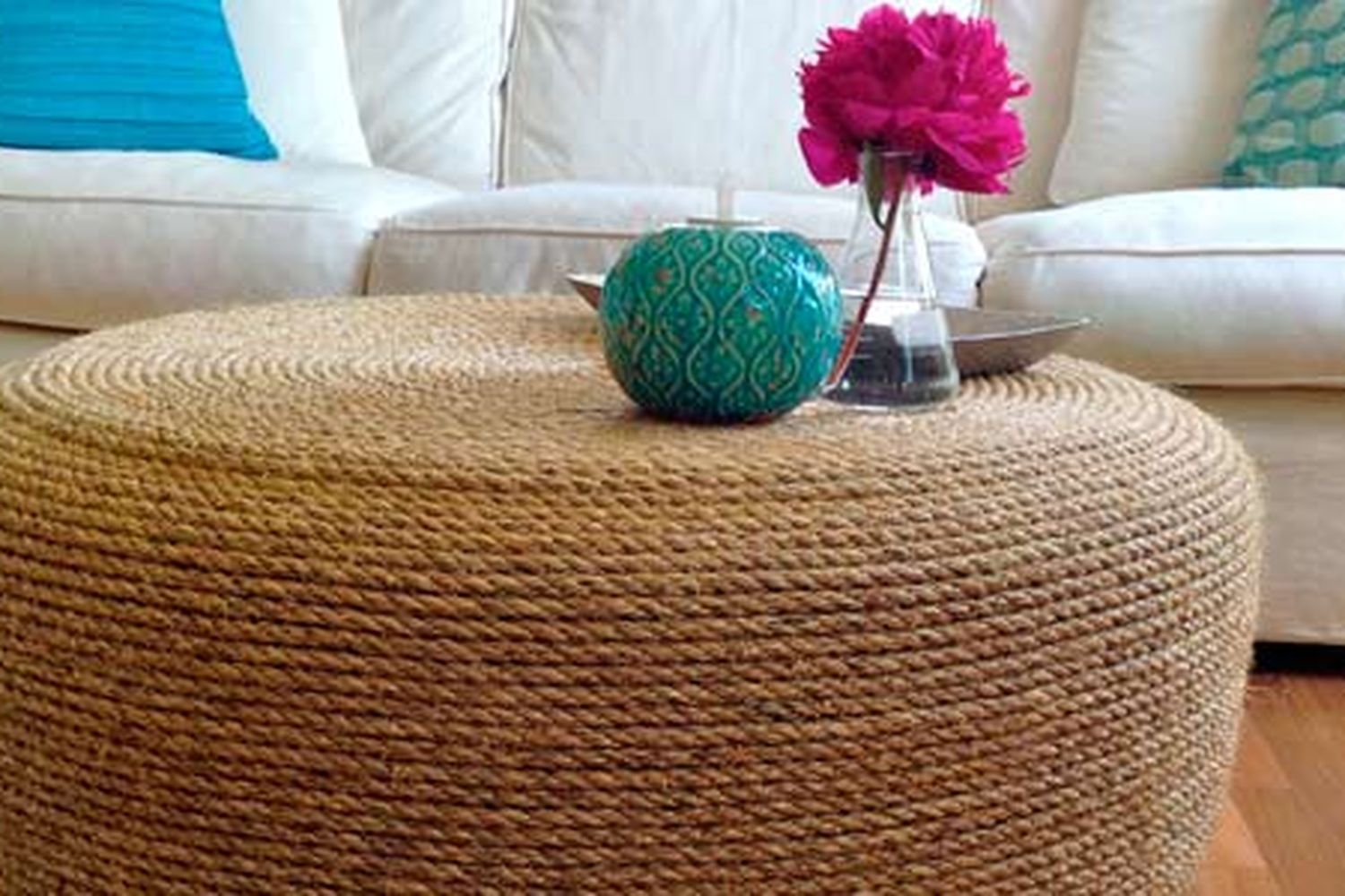 A rope ottoman in front of a white couch