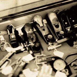 A collection of antique hand planes are displayed in a wooden box for sale.