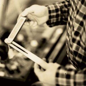 A person holds and inspects a folding ruler, a common antique tool.