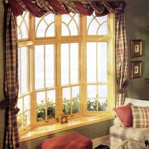 A bay window in a living room with red checkered curtains.