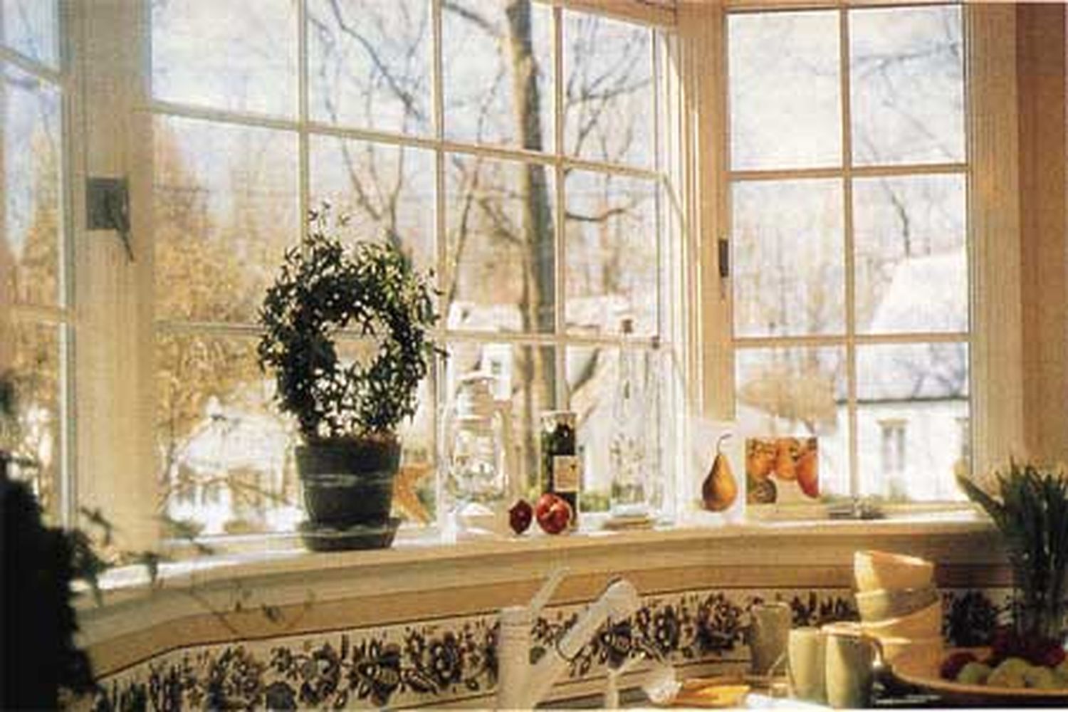 A Bay window with a potted plant sitting on it's sill.