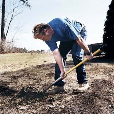 A man digs with his hands too far down the handle.