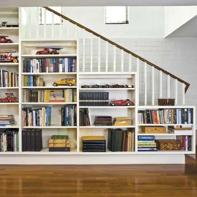 A set of storage shelves installed under a stairwell.