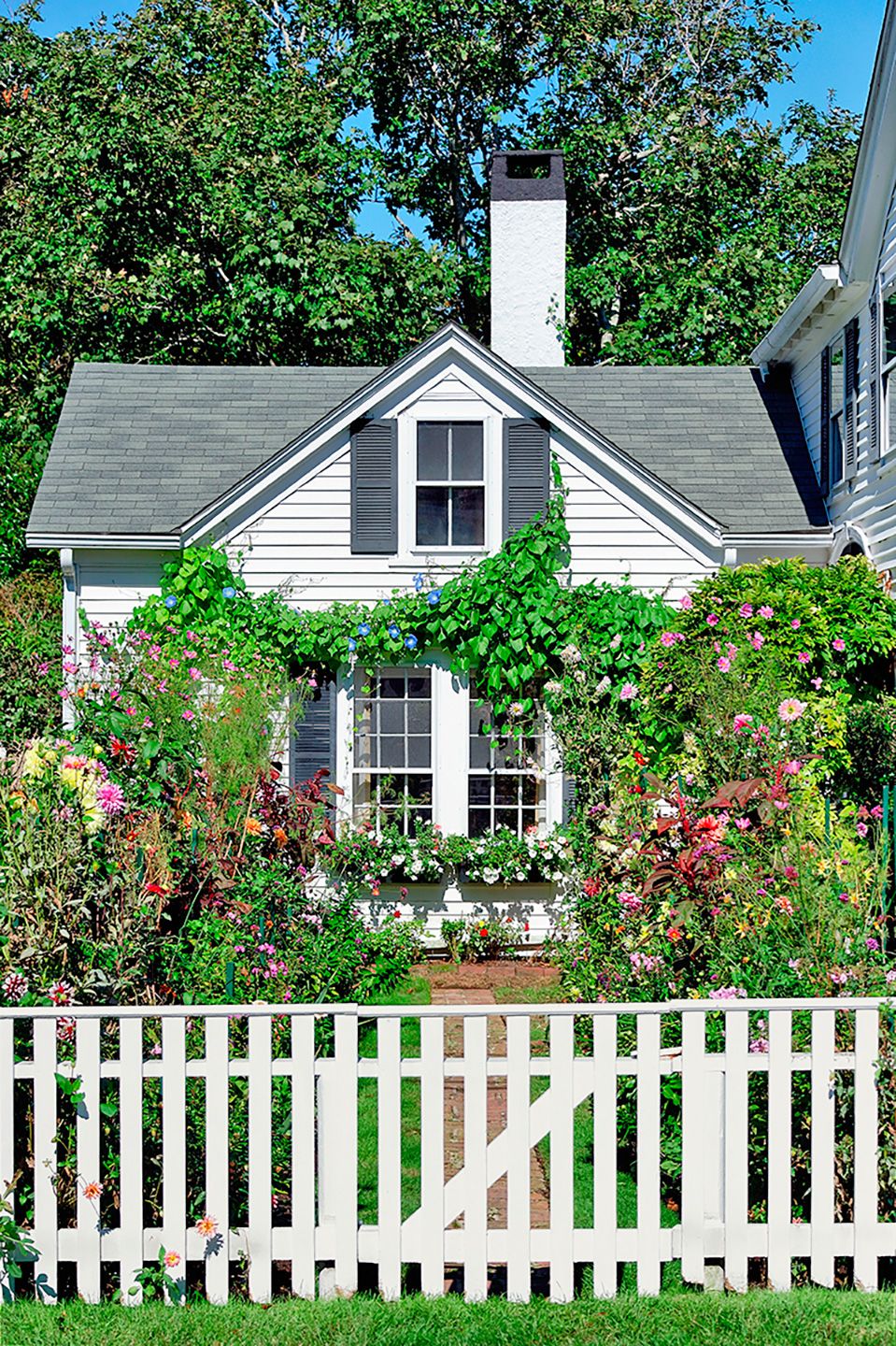 A capped picket fence in front of a home.