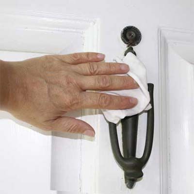 A door knocker is being wiped with car wax.