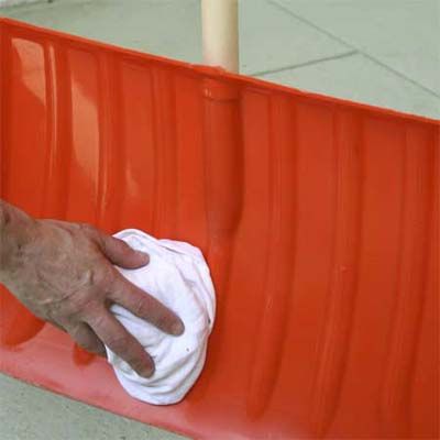 A snow shovel is being wiped with car wax.