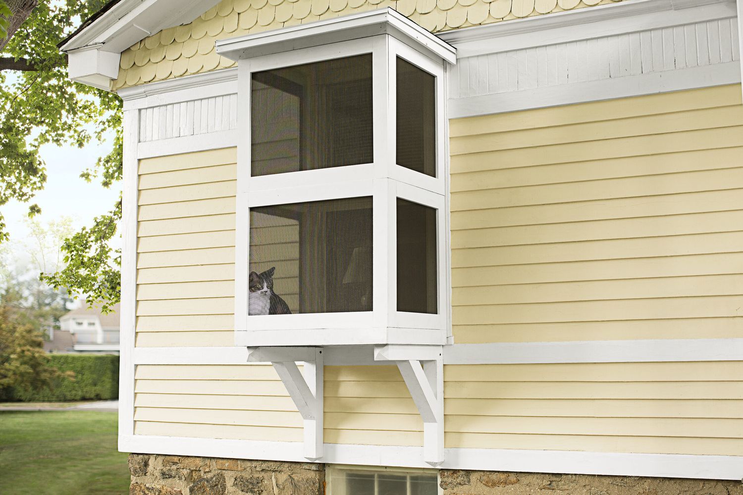 An outdoor catio attached to the side of a yellow house.