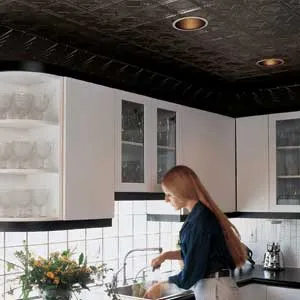 A woman in a kitchen with a black ceiling.