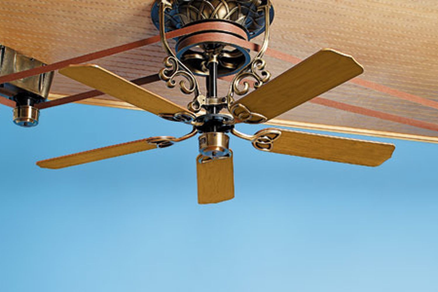 A ceiling fan on a brown ceiling.