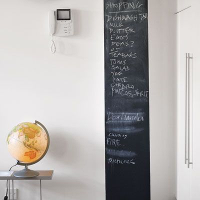 a large strip of chalkboard paint on a wall used as a shopping list