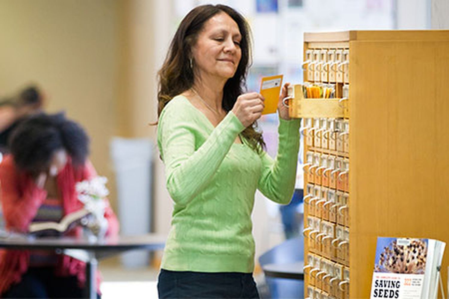 a woman checking seeds out of a library