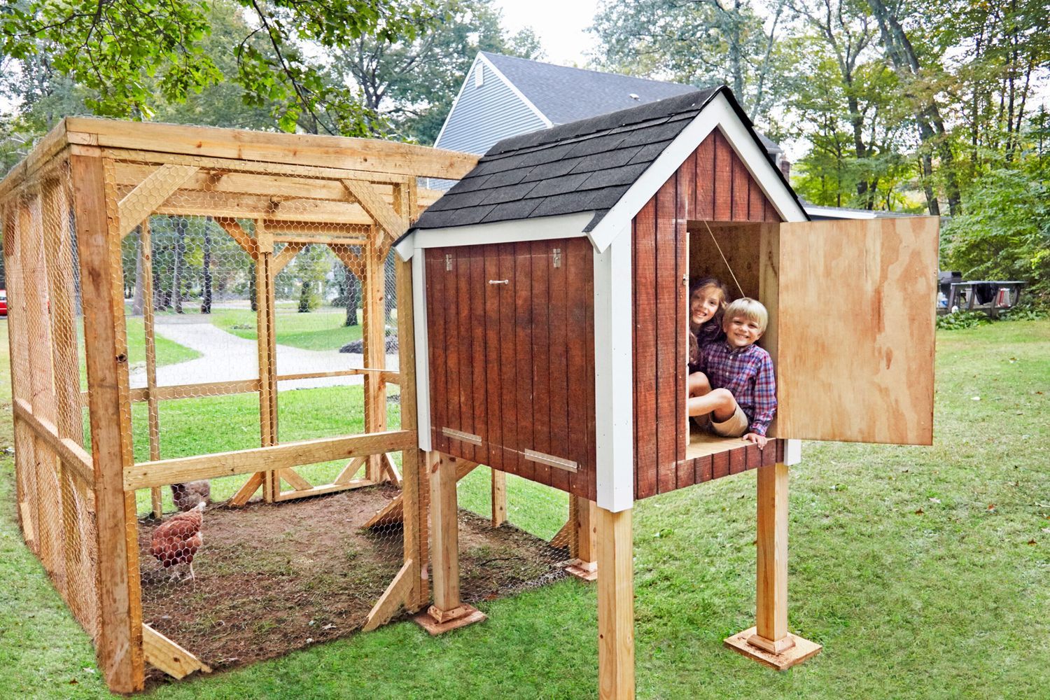 Two children and chickens in a chicken coop.