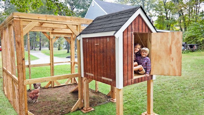 Two children and chickens in a chicken coop.