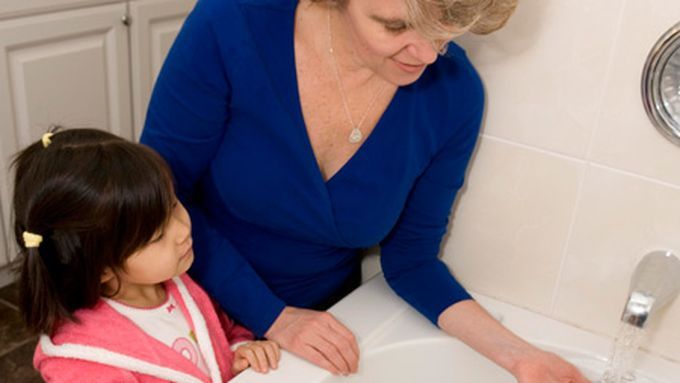 a woman walking a child through home safety procedures.