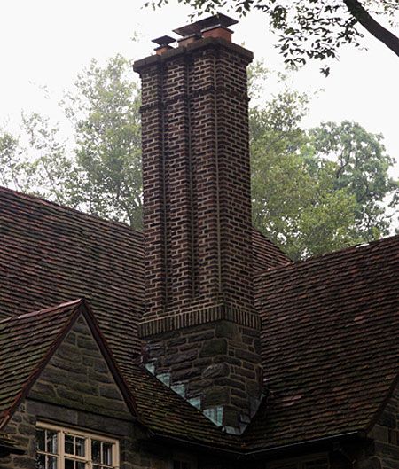 A chimney on top of a home with multiple flues.