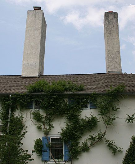 A house with 2 paired chimneys on the roof.