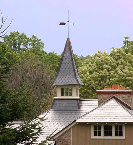 A triangle shaped cupola on the roof of a building.