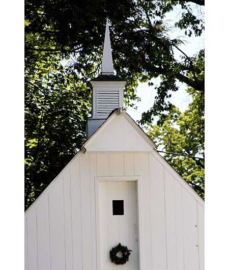 A pointed white cupola on the top of a building.