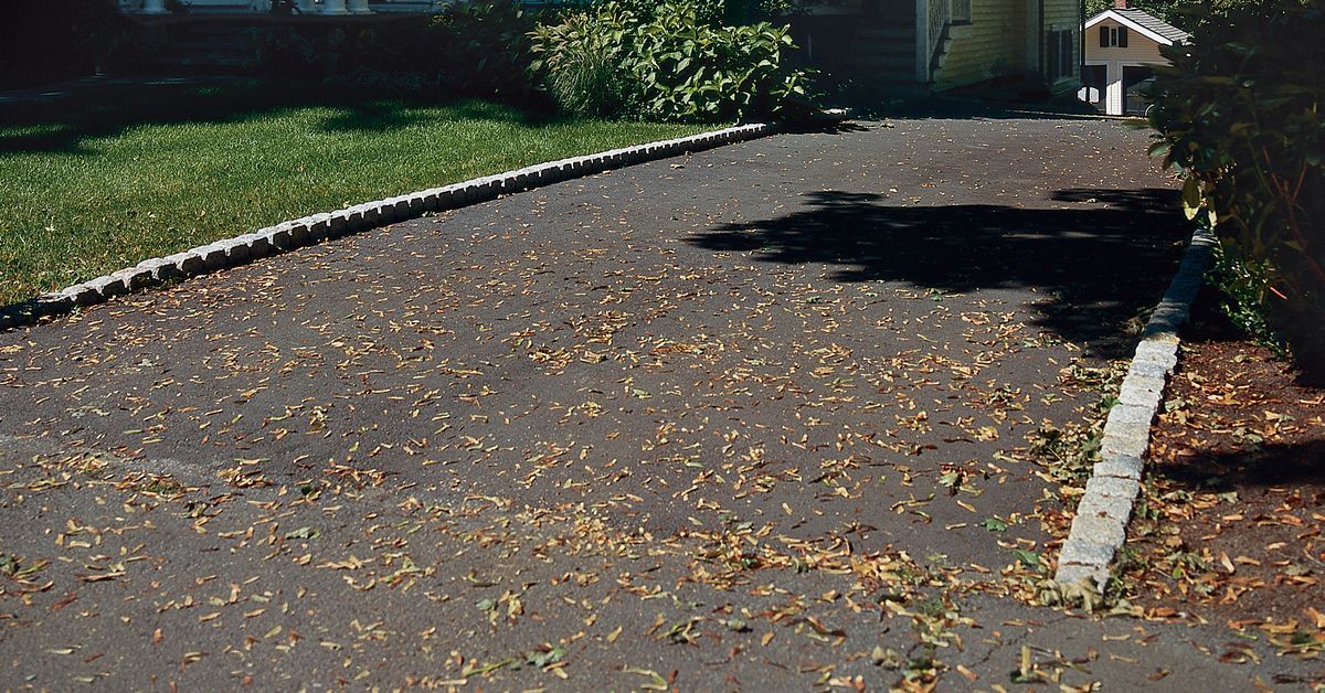 A belgian brick driveway leading up to a house.