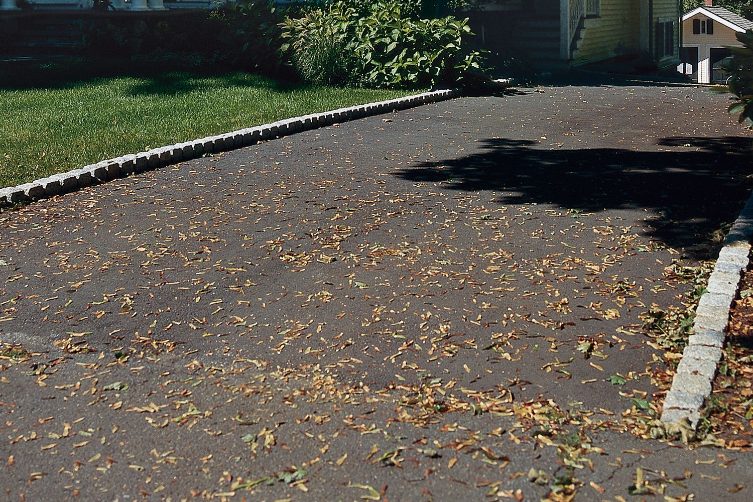 A belgian brick driveway leading up to a house.