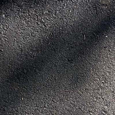 A driveway surface of plain asphalt.