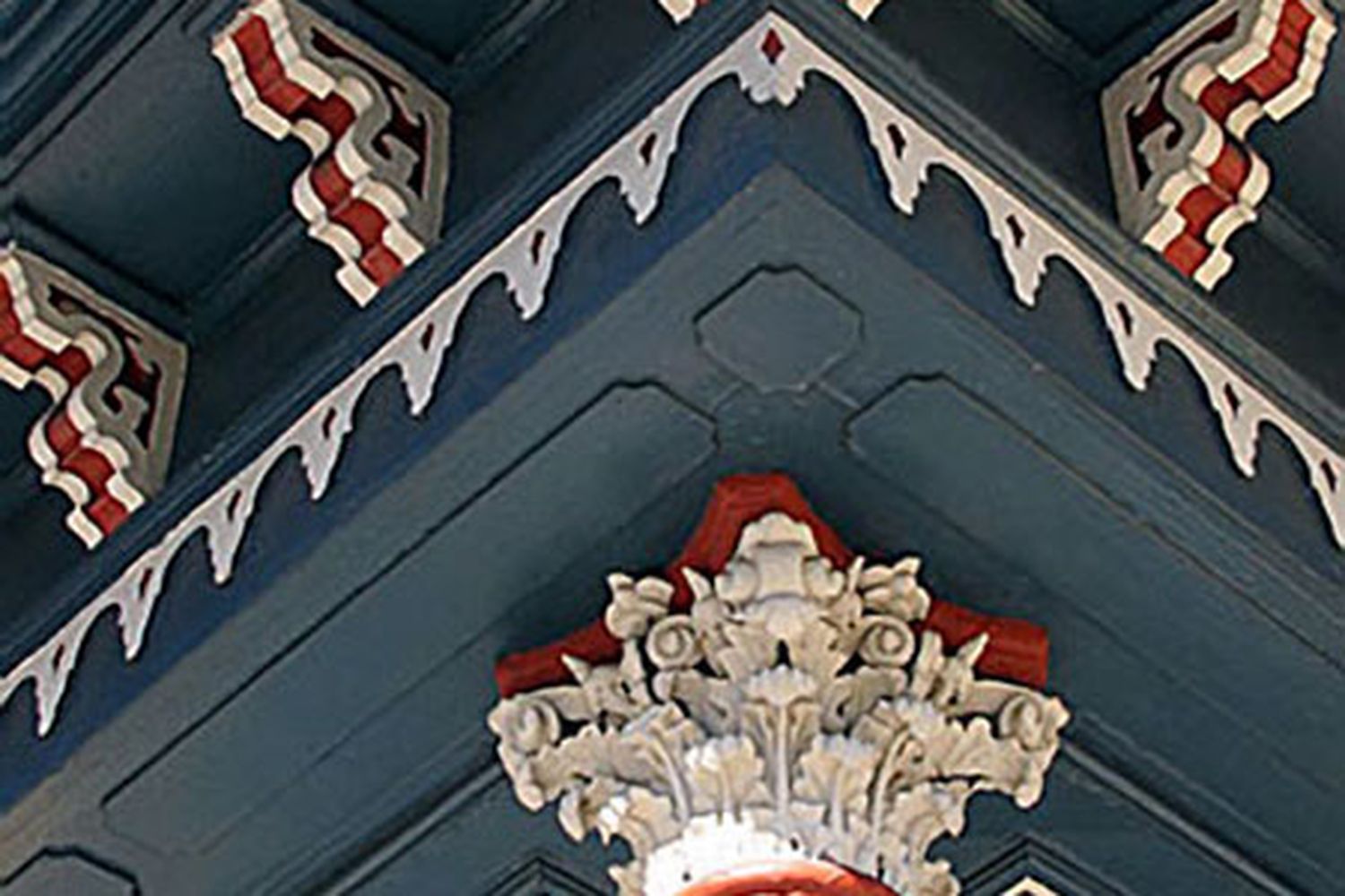 A building with Victorian designs and multicolored paint on it's exterior.