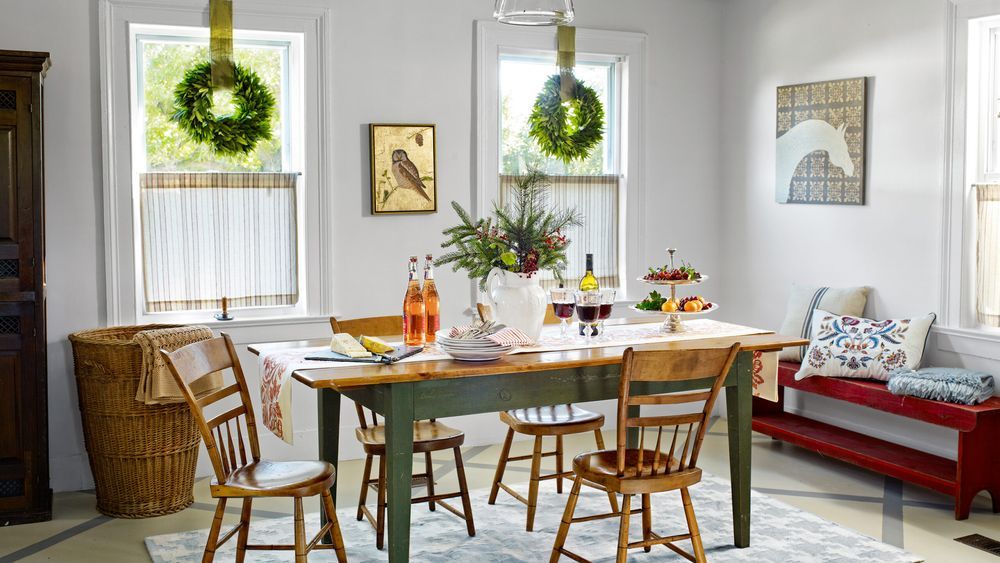 A farmhouse dining room with tables, bronze light fixtures and a spindle chairs.