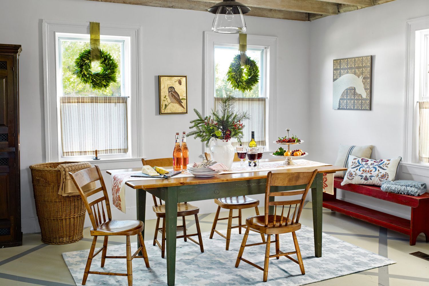 A farmhouse dining room with tables, bronze light fixtures and a spindle chairs.