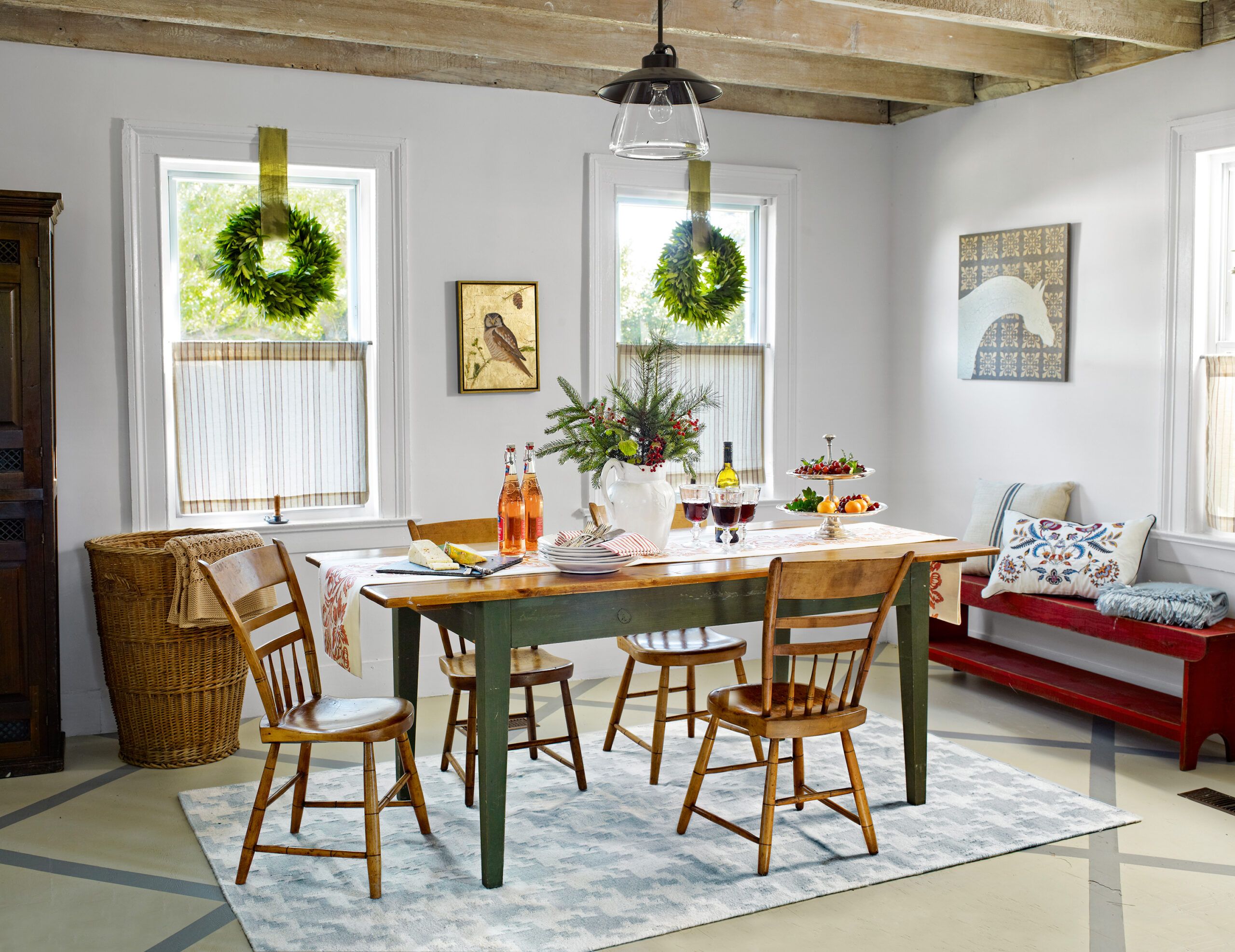 A farmhouse dining room with tables, bronze light fixtures and a spindle chairs.