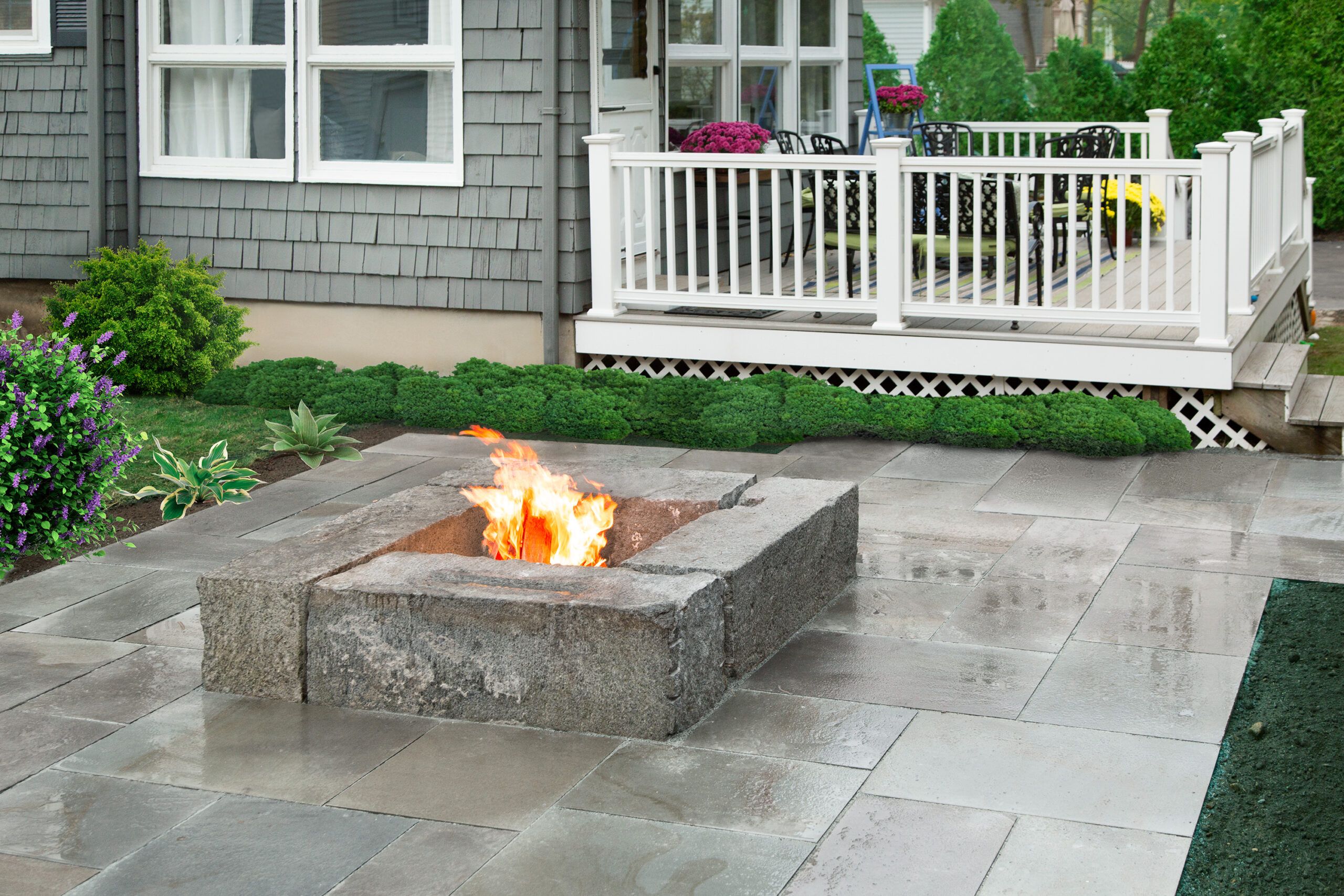 A homemade patio made of stone, including a stone fire pit.