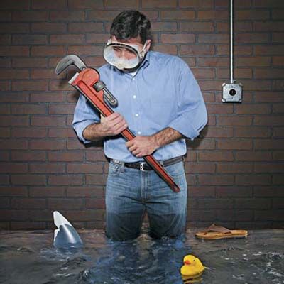 a man holds a wrench after water floods his home