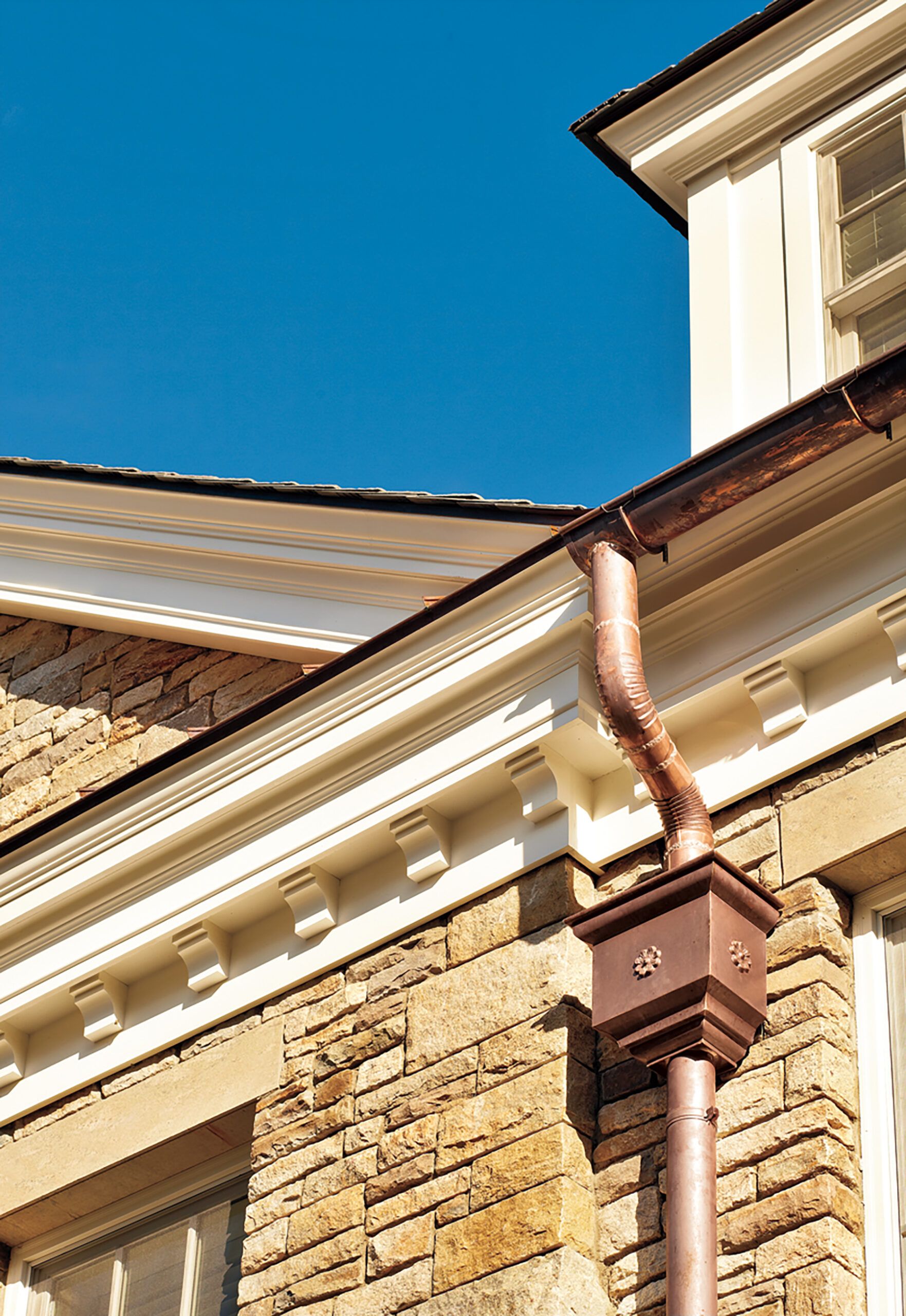 An image of a conductor head on the downspout of a home