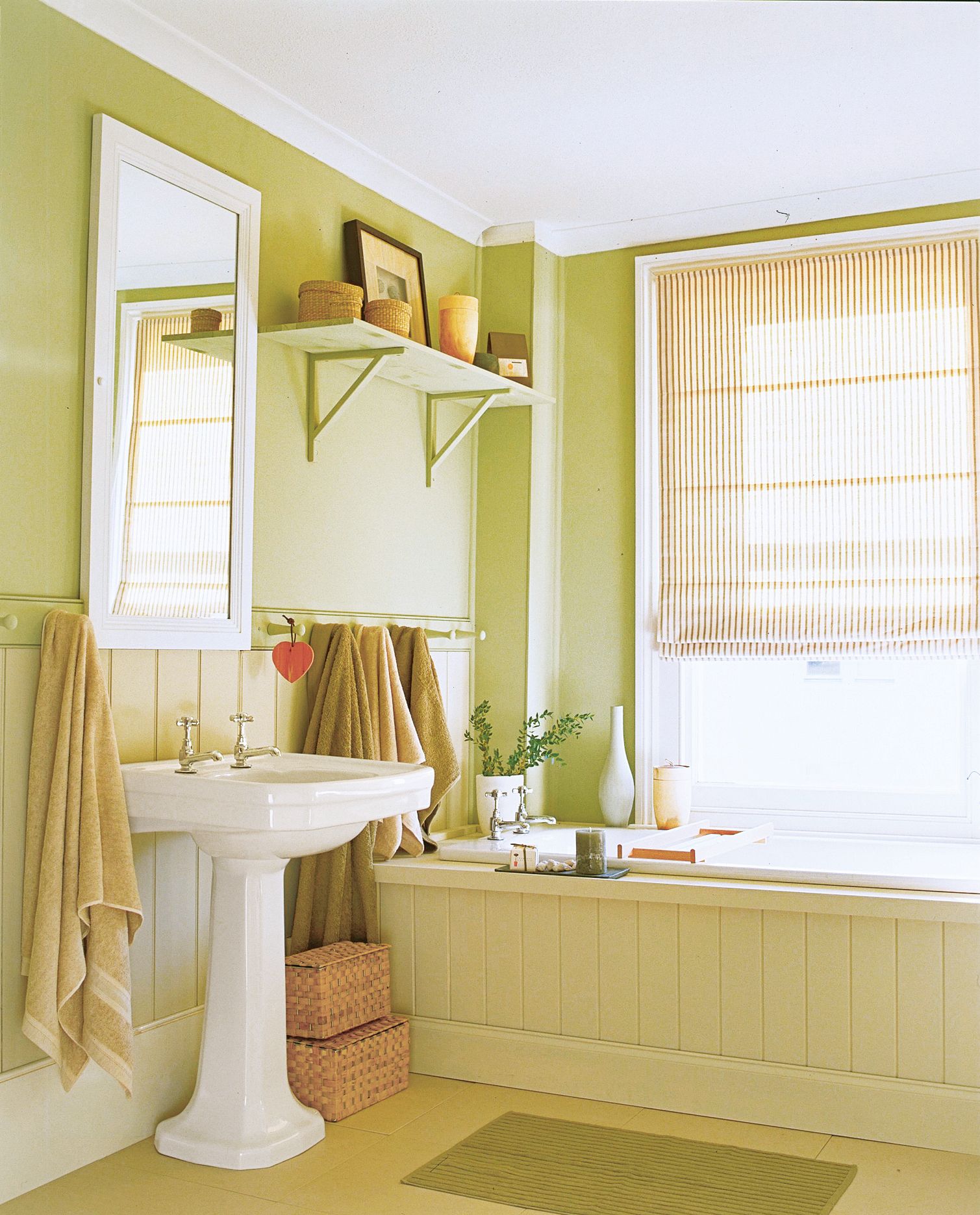 A bathroom with a pedestal sink and tall mirror.