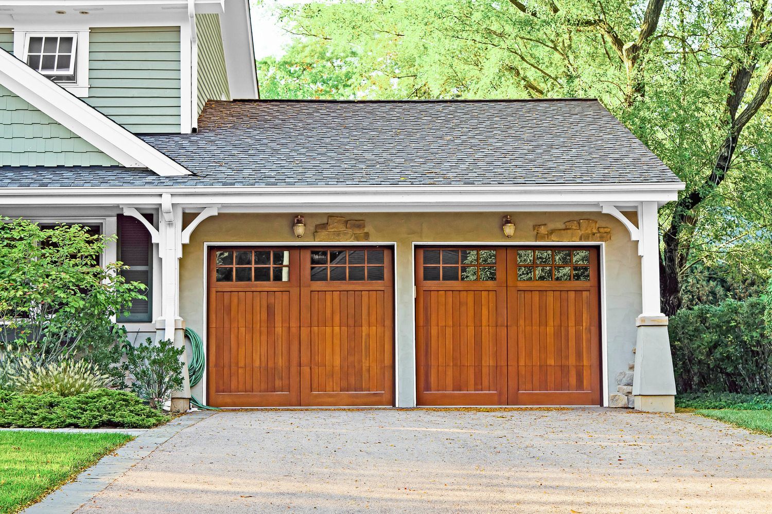 A double garage door at the end of a driveway.