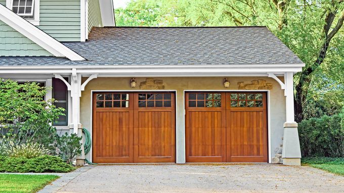 A double garage door at the end of a driveway.