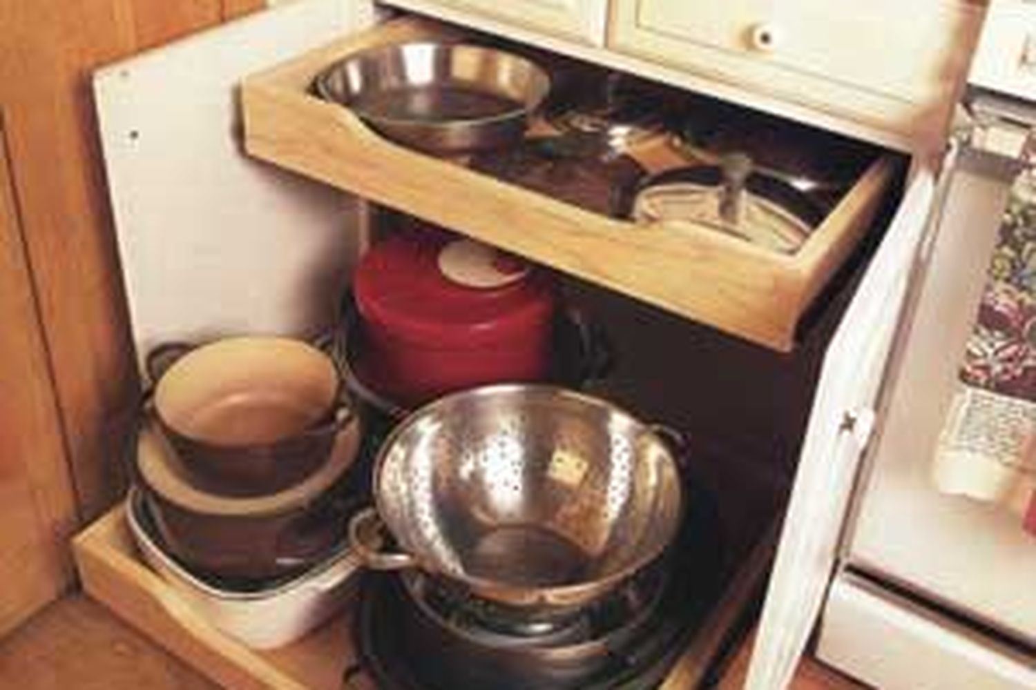 A kitchen cabinet with glide-out shelves