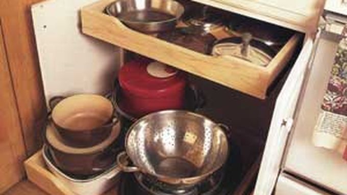 A kitchen cabinet with glide-out shelves