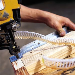 A nail gun being used to frame a house.