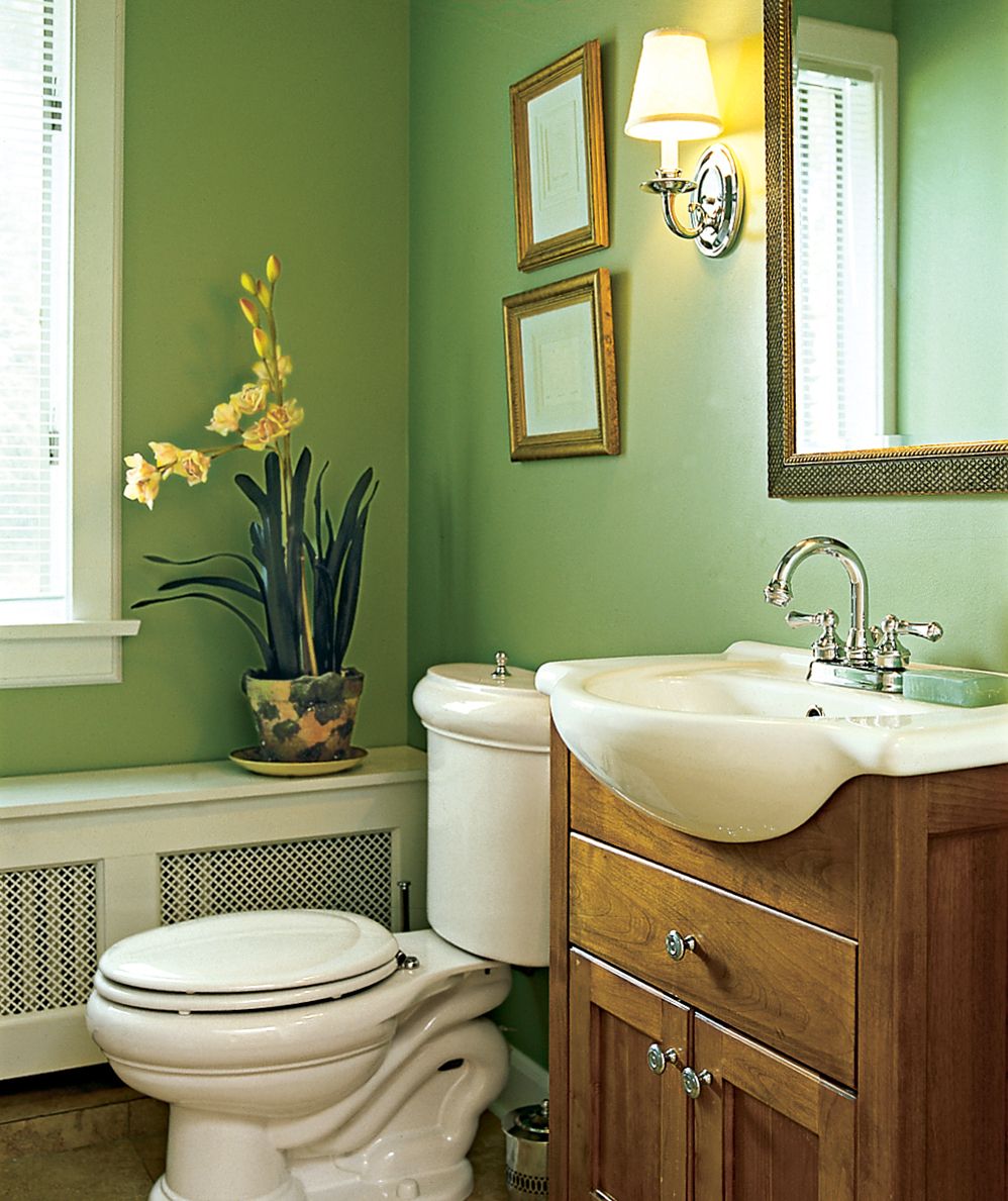 A bathroom with green walls and an extending sink basin.