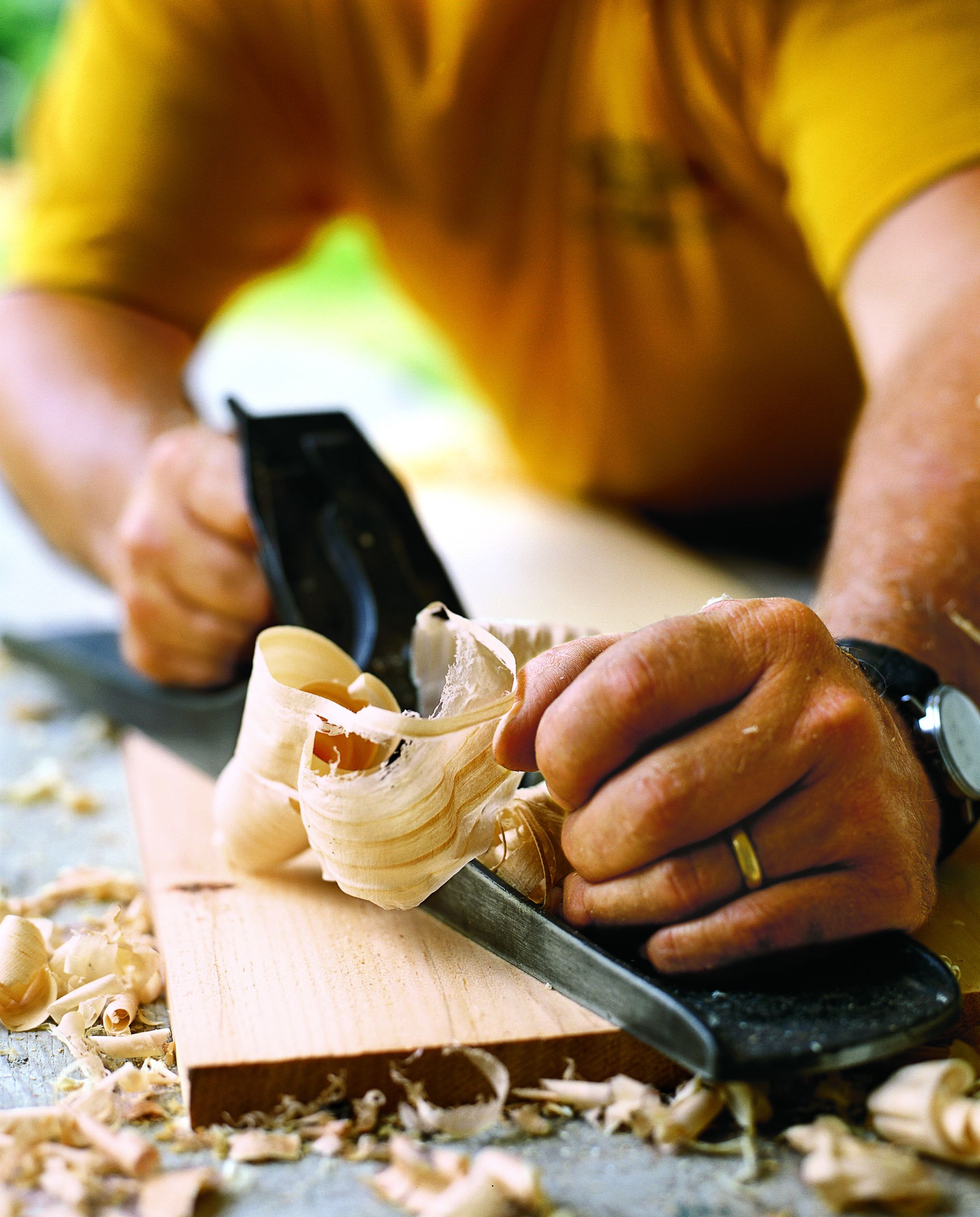 A hand plane being used to carve wood.