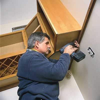 Tom Silva installs kitchen cabinets.