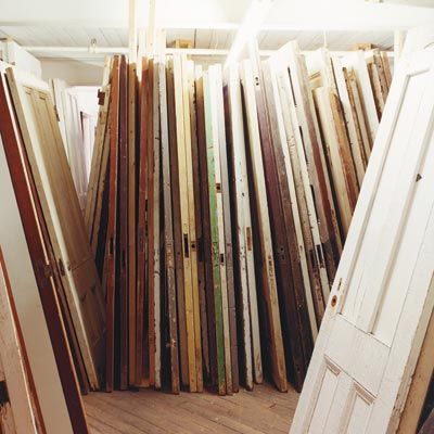 A room full of many different style wooden doors, some of which are better to turn into a headboard than others.