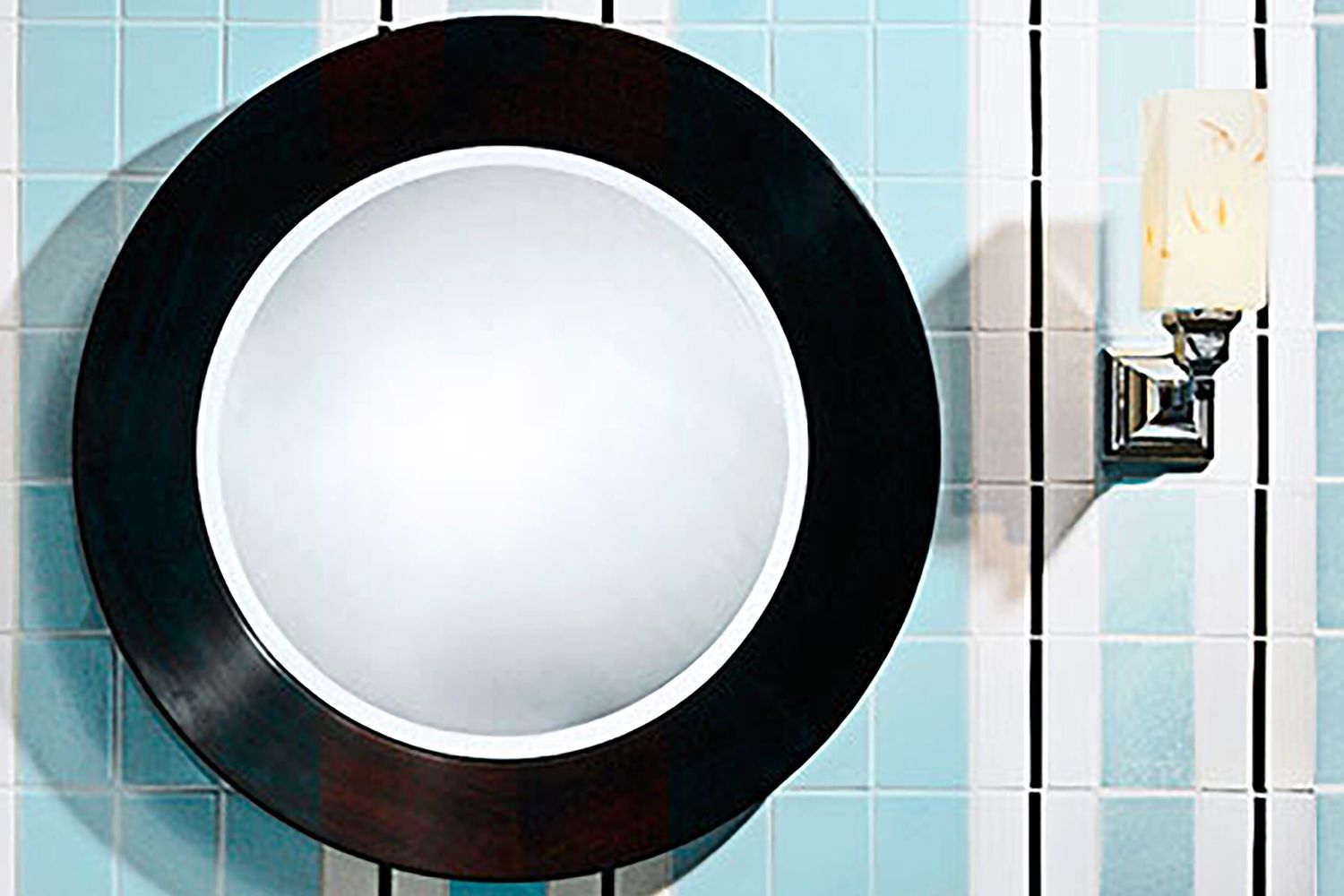 A tile wall with a light and bowl like fixture hanging from it.