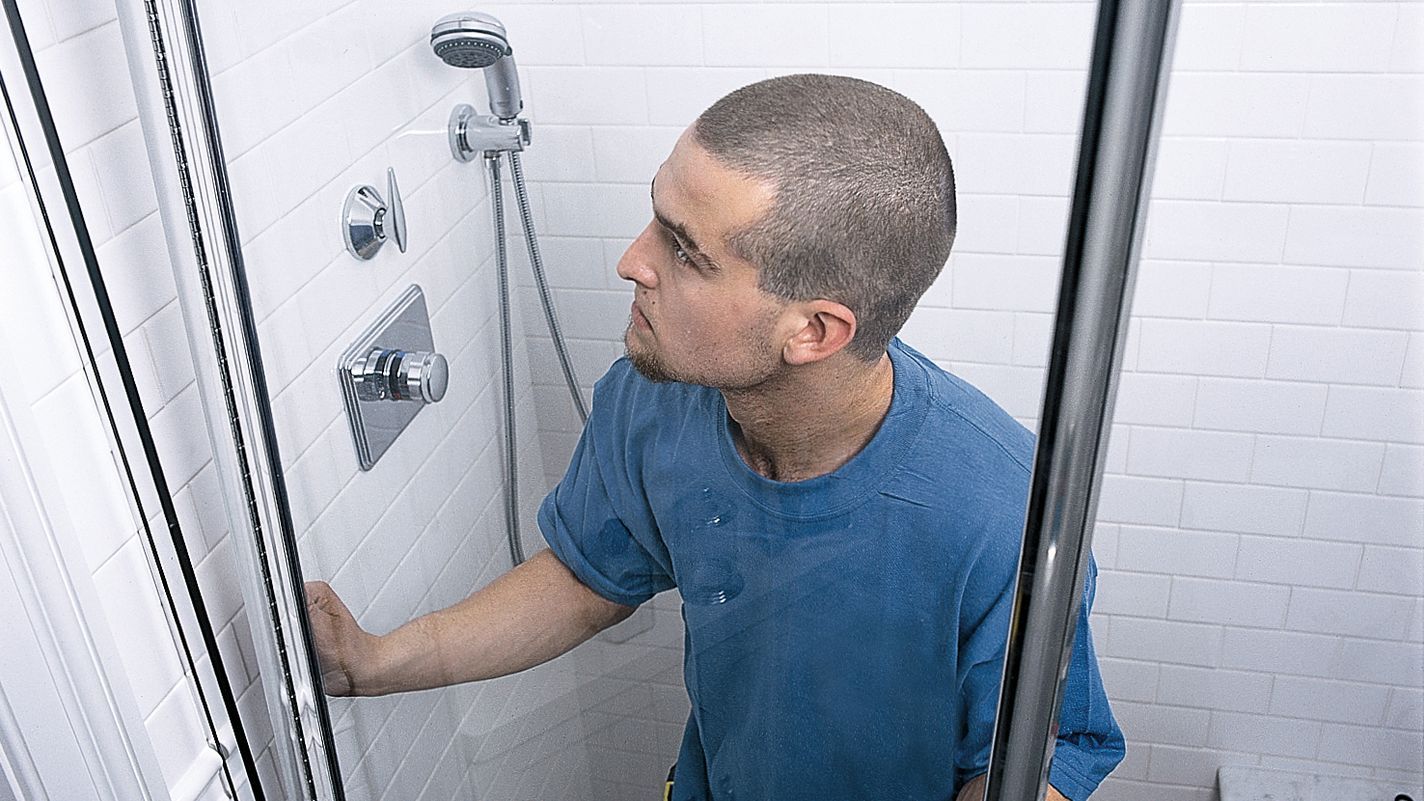 Photo of a worker installing a shower door