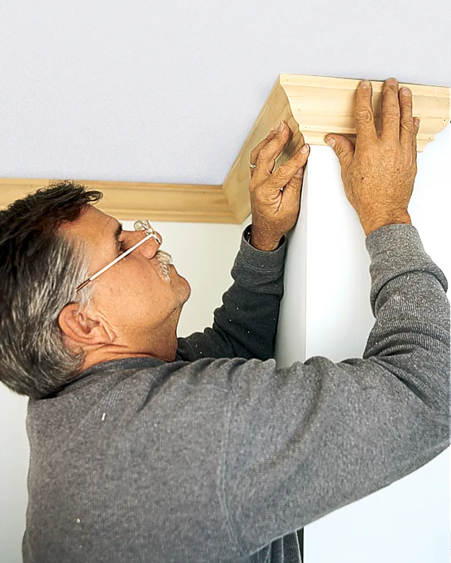 Man gluing crown molding