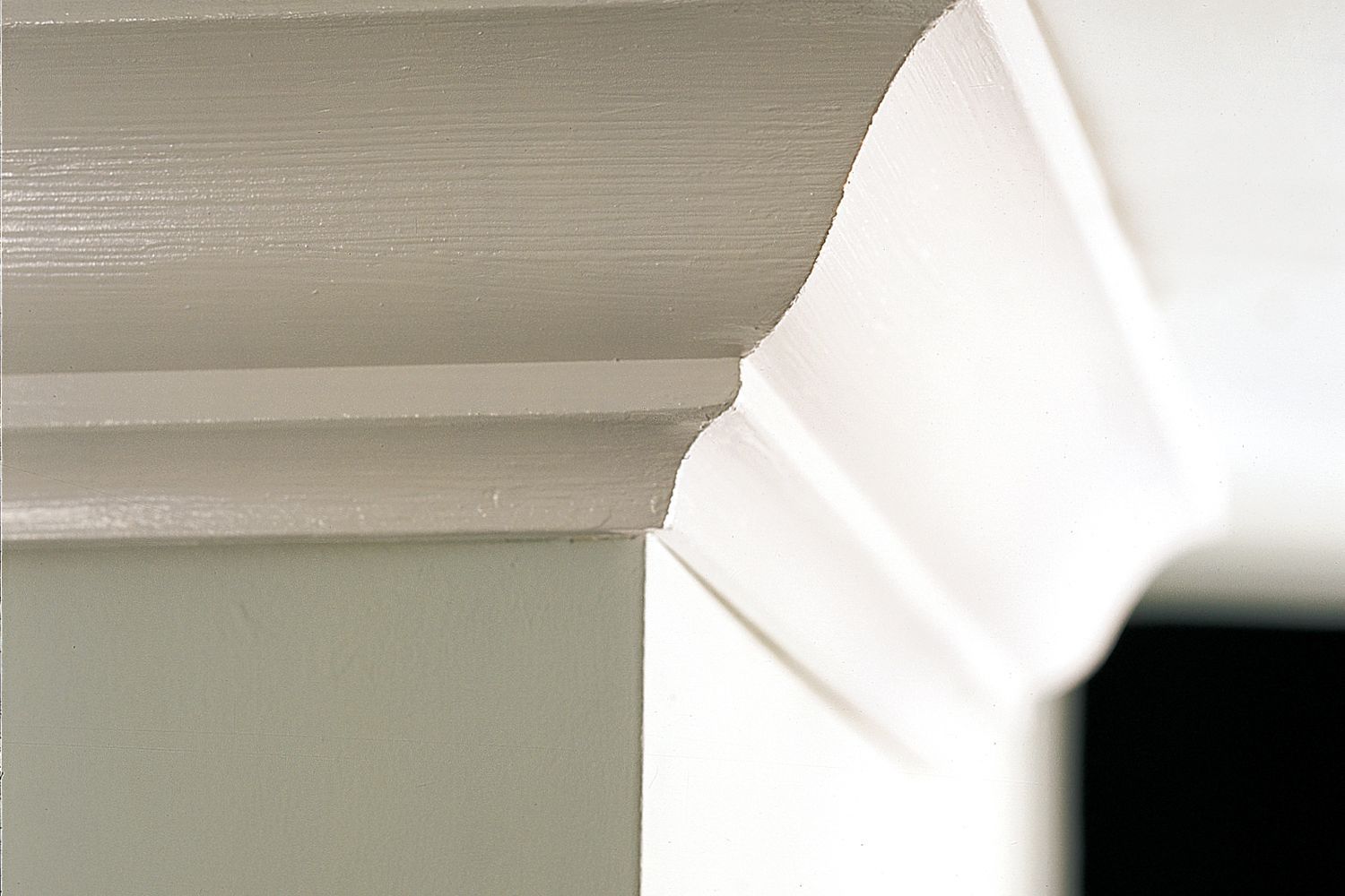 A zoomed in picture of crown molding affixed to the wall of a home.